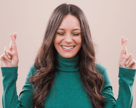 Woman smiling with fingers crossed